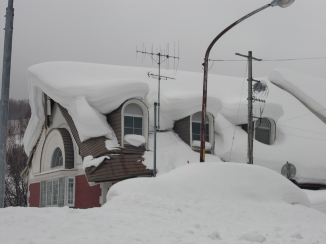 三角屋根に雪が積もっている画像